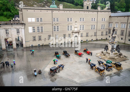 Salzburg, Austria - April 30, 2015: Horse driven carriages a rainy day. High angle view. Stock Photo