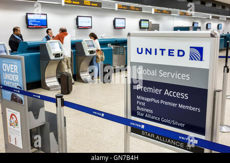 Miami Florida International Airport MIA,aviation,terminal,United Airlines,carrier,ticket counter,agent,job,Hispanic adult,adults,man men male,woman fe Stock Photo