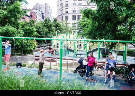 New York City,NY NYC Manhattan,Midtown,Union Square Park,public park,playground,swing,Black adult adults,woman female women,man men male,boy boys kids Stock Photo