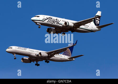 Alaska Airlines Boeing 737-490 (registration N767AS) flies next to United Airlines Boeing 757-224 (registration N41135) on approach to San Francisco International Airport (SFO) over San Mateo, California, United States of America Stock Photo