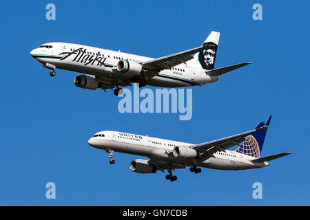 Alaska Airlines Boeing 737-490 (registration N767AS) flies next to United Airlines Boeing 757-224 (registration N41135) on approach to San Francisco International Airport (SFO) over San Mateo, California, United States of America Stock Photo