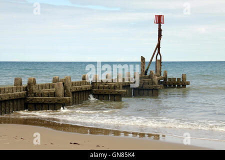 A groyne stretching out to sea on Overstrand Beach in Norfolk Stock Photo