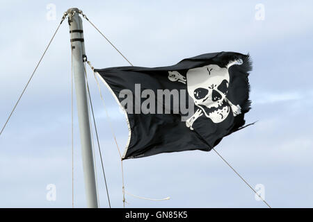 Skull & Crossbones flag displayed on boat moored off Blakeney in Norfolk Stock Photo