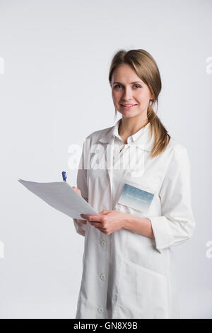 Beautiful nurse smiling and taking notes on a white isolated background Stock Photo