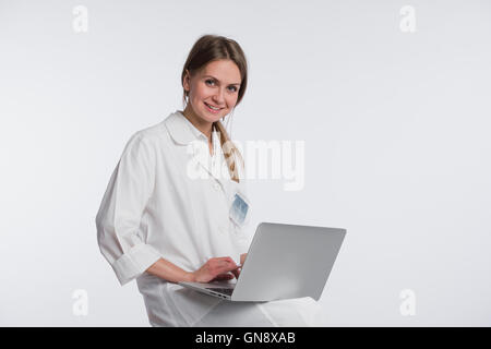 Smiling female doctor working on her laptop against a white background Stock Photo