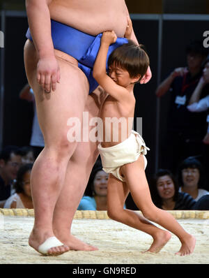 Tokyo, Japan. 28th Aug, 2016. A youngster tackles with all his might a Goliath-like sumo wrestlers during a promotional event at a commercial complex next to Tokyo central station on Sunday, August 28, 2016. A full lineup of top division sumo wrestlers participated in the event aiming at introducing the culture of sumo wrestling to foreign visitors. Credit:  Natsuki Sakai/AFLO/Alamy Live News Stock Photo