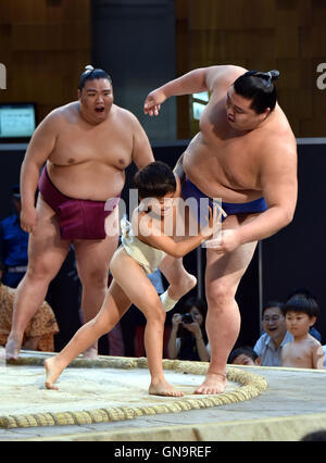 Tokyo, Japan. 28th Aug, 2016. A youngster tackles with all his might a Goliath-like sumo wrestlers during a promotional event at a commercial complex next to Tokyo central station on Sunday, August 28, 2016. A full lineup of top division sumo wrestlers participated in the event aiming at introducing the culture of sumo wrestling to foreign visitors. Credit:  Natsuki Sakai/AFLO/Alamy Live News Stock Photo