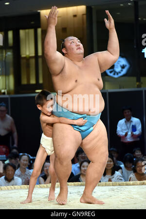 Tokyo, Japan. 28th Aug, 2016. A youngster tackles with all his might a Goliath-like sumo wrestlers during a promotional event at a commercial complex next to Tokyo central station on Sunday, August 28, 2016. A full lineup of top division sumo wrestlers participated in the event aiming at introducing the culture of sumo wrestling to foreign visitors. Credit:  Natsuki Sakai/AFLO/Alamy Live News Stock Photo