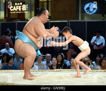 Tokyo, Japan. 28th Aug, 2016. A youngster tackles with all his might a Goliath-like sumo wrestlers during a promotional event at a commercial complex next to Tokyo central station on Sunday, August 28, 2016. A full lineup of top division sumo wrestlers participated in the event aiming at introducing the culture of sumo wrestling to foreign visitors. Credit:  Natsuki Sakai/AFLO/Alamy Live News Stock Photo