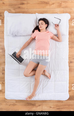 Washed out young woman sleeping on bed Stock Photo