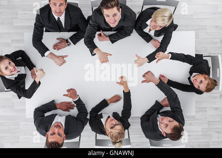 Diverse business people sitting around the table on a meeting and smiling Stock Photo