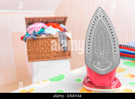 Beautiful a modern iron on an ironing board. Stock Photo