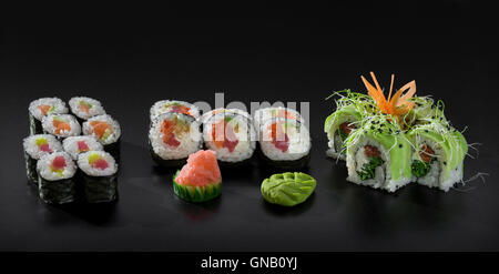 Mix colorful sushi. Uramaki and Hosomaki sushi rolls over black background Stock Photo
