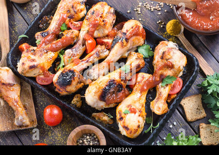 Hot and spicy chicken drumsticks on serving pan Stock Photo