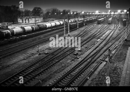 Sorting railway station with cargo trains on rails at night, black and white photo Stock Photo