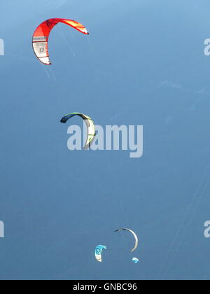 Close-up of multicolored kites surfers on blue sky background Stock Photo