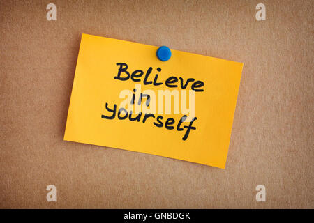 Yellow paper note with phrase Believe In Yourself. Close up. Stock Photo