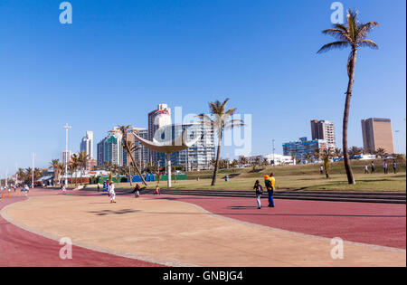 Many unknown people enjoy an early morning walk along promenade on beach front Stock Photo