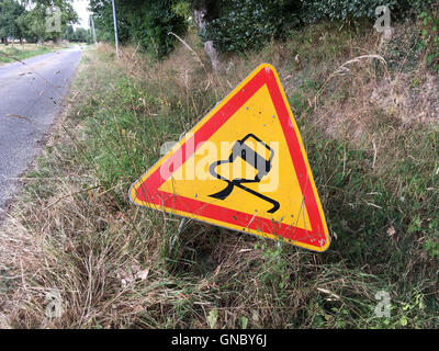 Road sign telling that the road in slippery Stock Photo