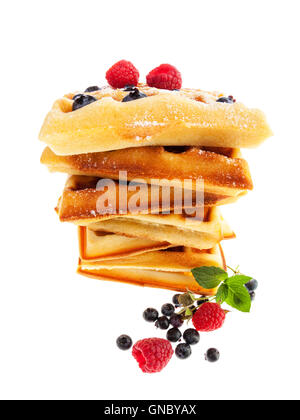 Fish eye view of stacked waffles with raspberries, blueberries and icing sugar isolated on white background Stock Photo