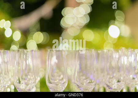 Row of wine glasses in green background painted with beautiful bokeh. Stock Photo