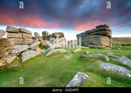 Dramatic clouds lit by the sunset over Combestone Tor on Dartmoor National Park in Devon Stock Photo