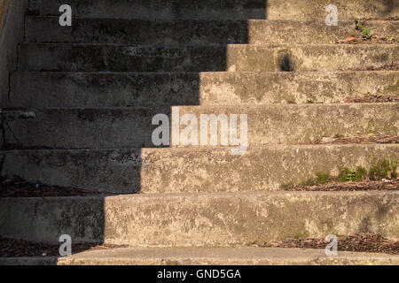 Old stairs in an abandoned house, diagonally divided into a light and shady part. Stock Photo