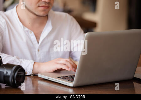 photographer with the camera works on his laptop Stock Photo