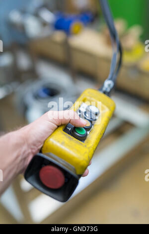 Industrial worker pushing on button of machinery controler. Stock Photo