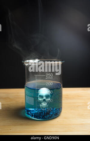 Close up glass measuring beaker with poison skull Stock Photo