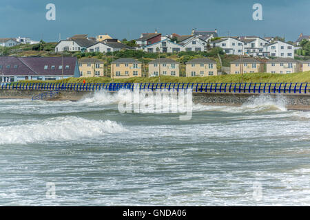 Waves crash in to the sea wall at Trearddur Bay on Anglesey Stock Photo