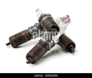 Four used, worn and dirty spark plugs from a car. Stock Photo