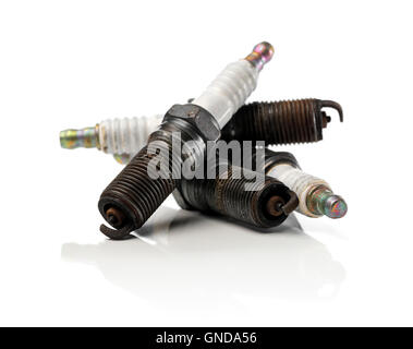 Four old used and dirty spark plugs from a car. Stock Photo