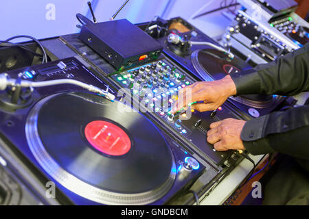 The DJ, Disc Jockey, plays vinyl records and music for a party. Stock Photo