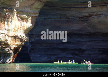 Group of kayakers paddling through Lover's Leap arc at Pictured Rocks National Park, MI, USA Stock Photo