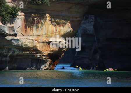 Group of kayakers paddling through Lover's Leap arc at Pictured Rocks National Park, MI, USA Stock Photo