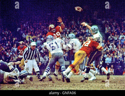 Dallas Cowboys quarterback Roger Staubach (12) looks for a receiver during  the NFC Championship game against the Washington Redskins at RFK Stadium in  Washington, DC on December 31, 1972. Blocking for Staubach