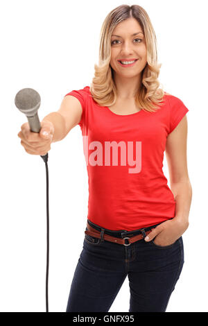 Young woman holding a microphone and doing an interview isolated on white background Stock Photo