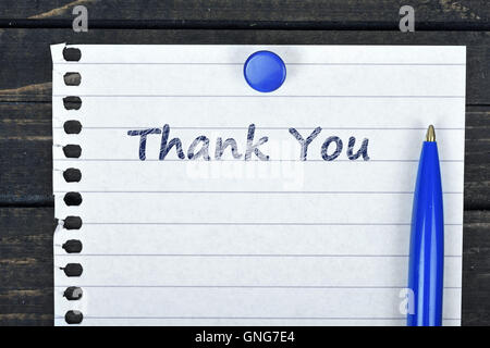 Thank You text on page and pen on wooden table Stock Photo