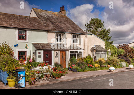 Cottages with lovely summer gardens and a decorated dustbin in Main Street, Ravenglass, Cumbria, England, UK Stock Photo
