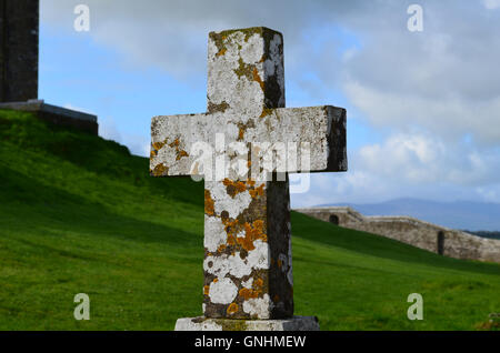 Old stone cross in Ireland with lichen growing on it in Ireland. Stock Photo