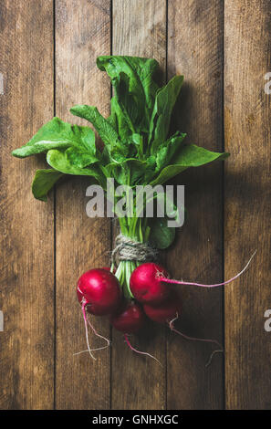 Fresh radish bunch over wooden background, top view, vertical composition Stock Photo