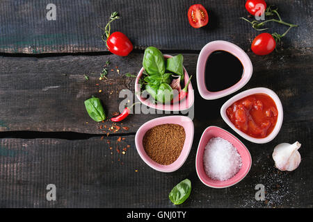 Ingredients for making homemade tomato ketchup sauce. Chopped tomatoes, salt, sugar, balsamic vinegar, herbs and chili peppers i Stock Photo