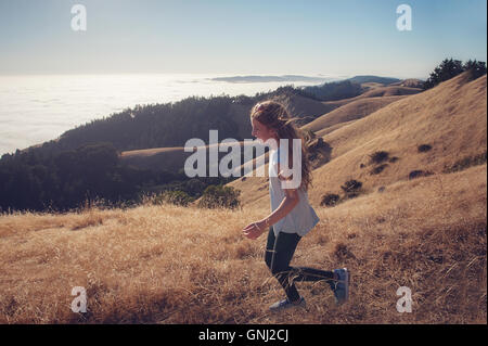 Girl running down mountain, California, United States Stock Photo
