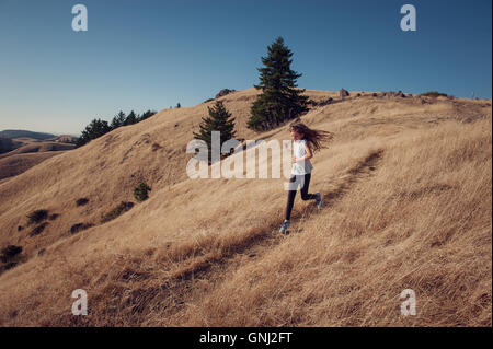 Girl running down mountain, California, United States Stock Photo
