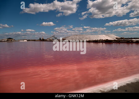 View of a salt factory near Aigues-Mortes in Camargue, southern France. Industry with heavy equipment for sea salt extraction Stock Photo