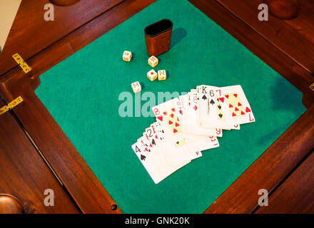 Vintage Gambling table with playing cards and dices, green background. Stock Photo