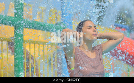 Beautiful woman enjoying under a water jet with thousands of drops in the background Stock Photo