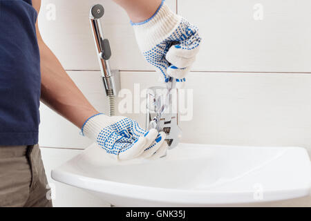 Closeup man fixing sink in a bathroom Stock Photo