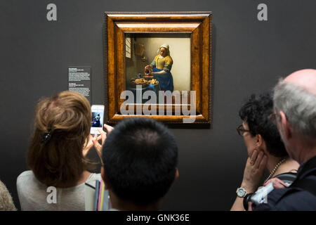 Taking iPhone smartphone photograph of painting by Johannes Vermeer 'The Milkmaid' at Rijksmuseum, Amsterdam, Holland Stock Photo